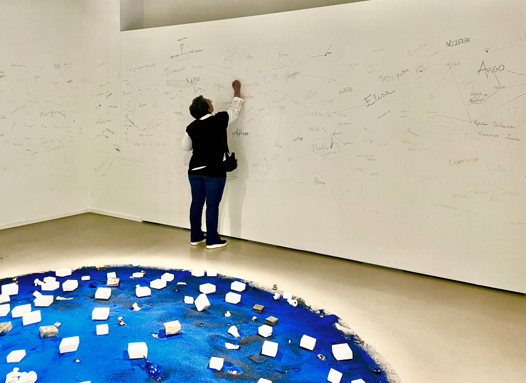 Visitatrice scrive sul muro delle costellazioni