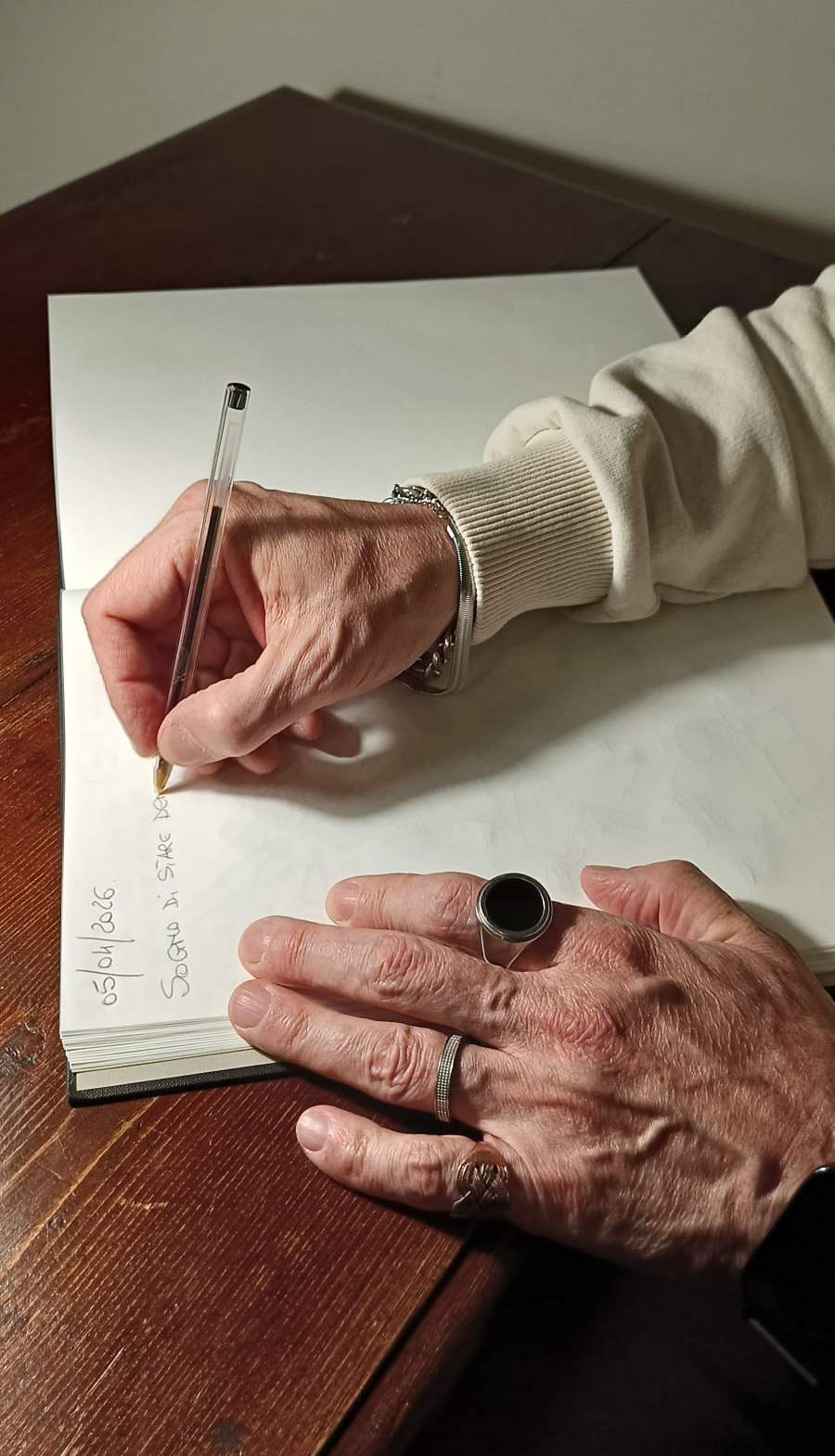 Dettaglio della mano che scrive '05/04/2026 — Sogno di stare...'