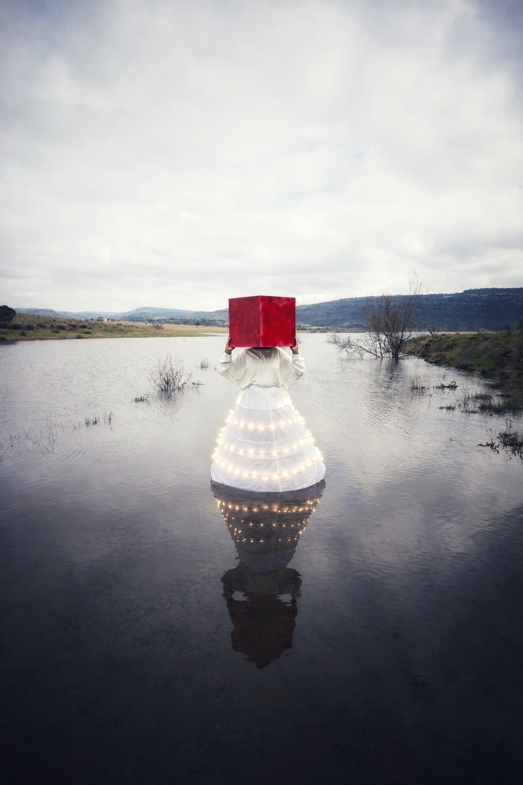 Opera — figura con cubo rosso sull'acqua
