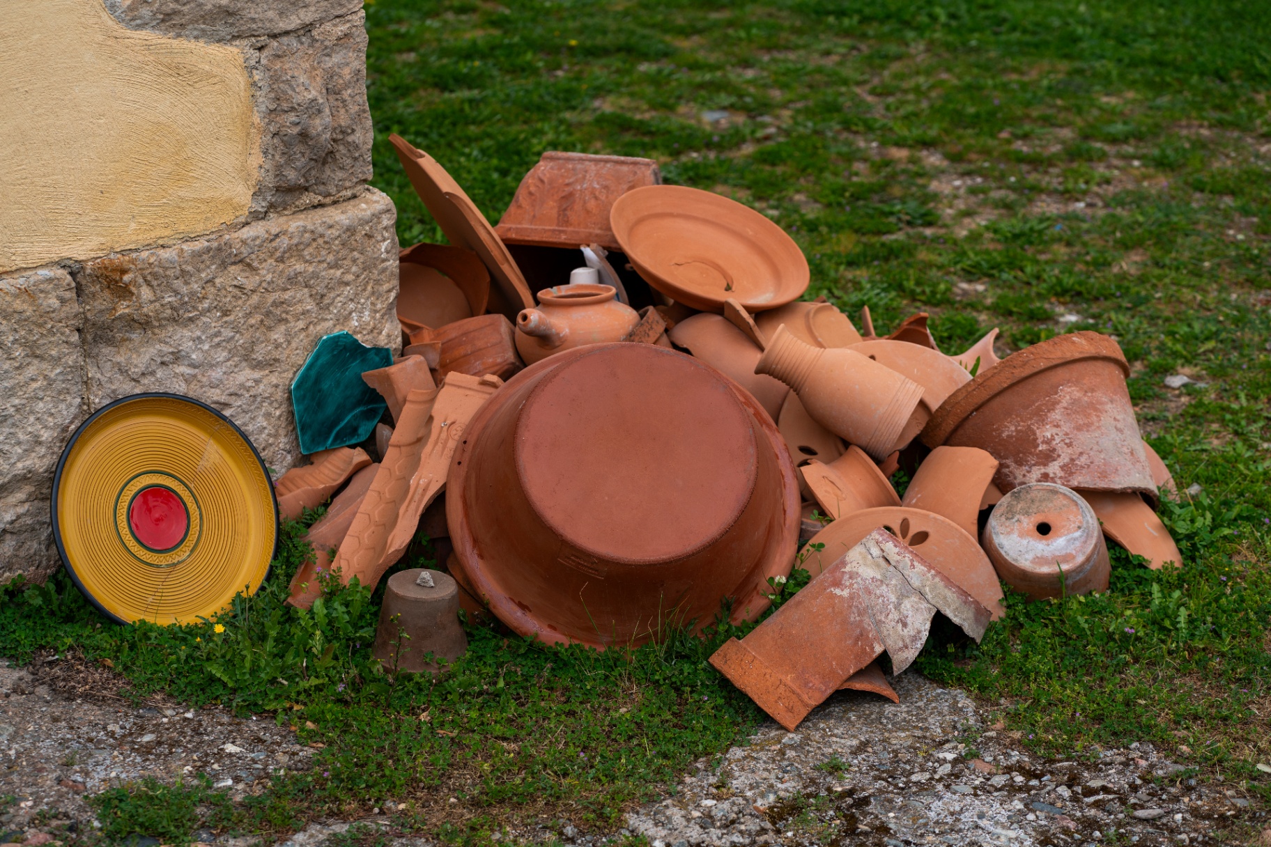 Campo luminoso — cumulo di vasi e frammenti in terracotta all'esterno