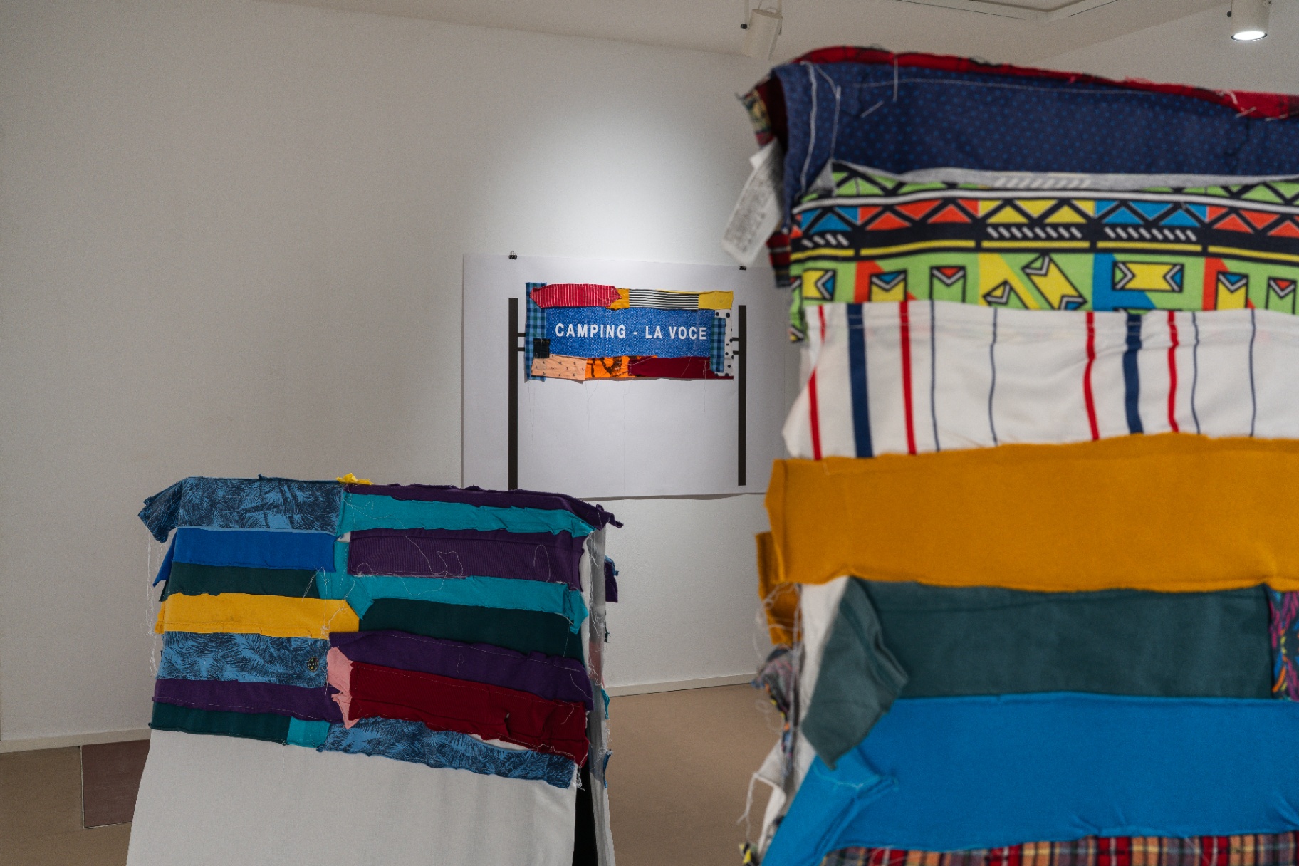 Giuseppe Loi — dettaglio dell'installazione tessile con scritta e superfici cucite